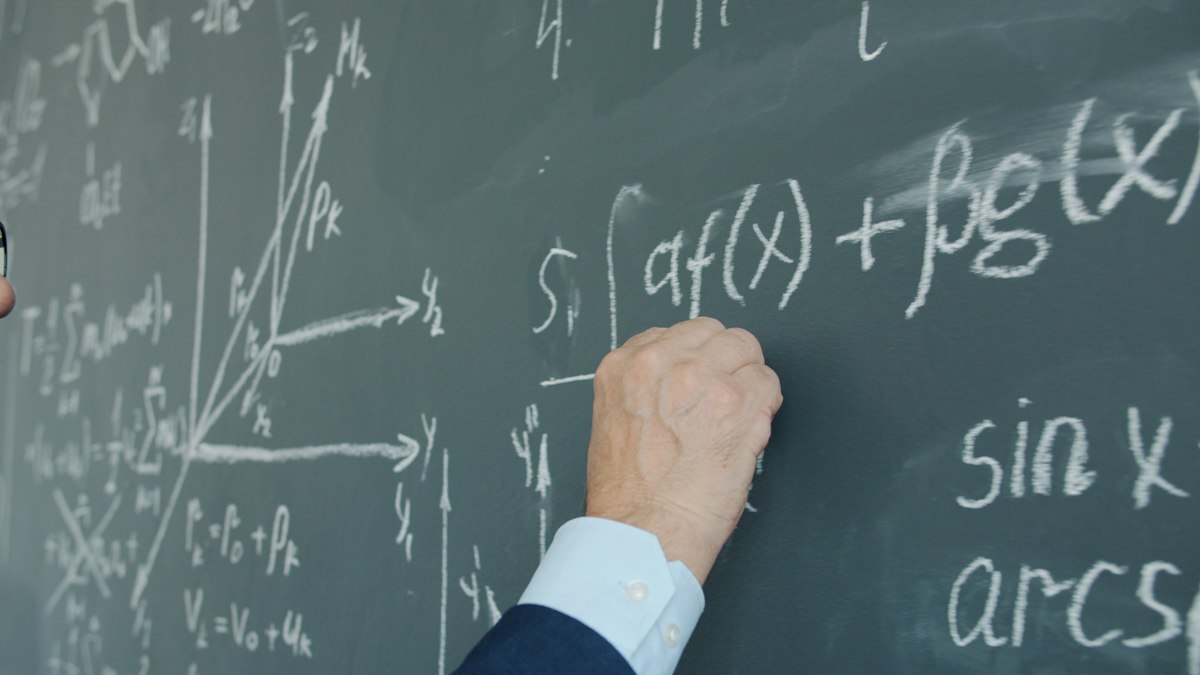 Formules mathématiques écrites à la craie sur un tableau noir